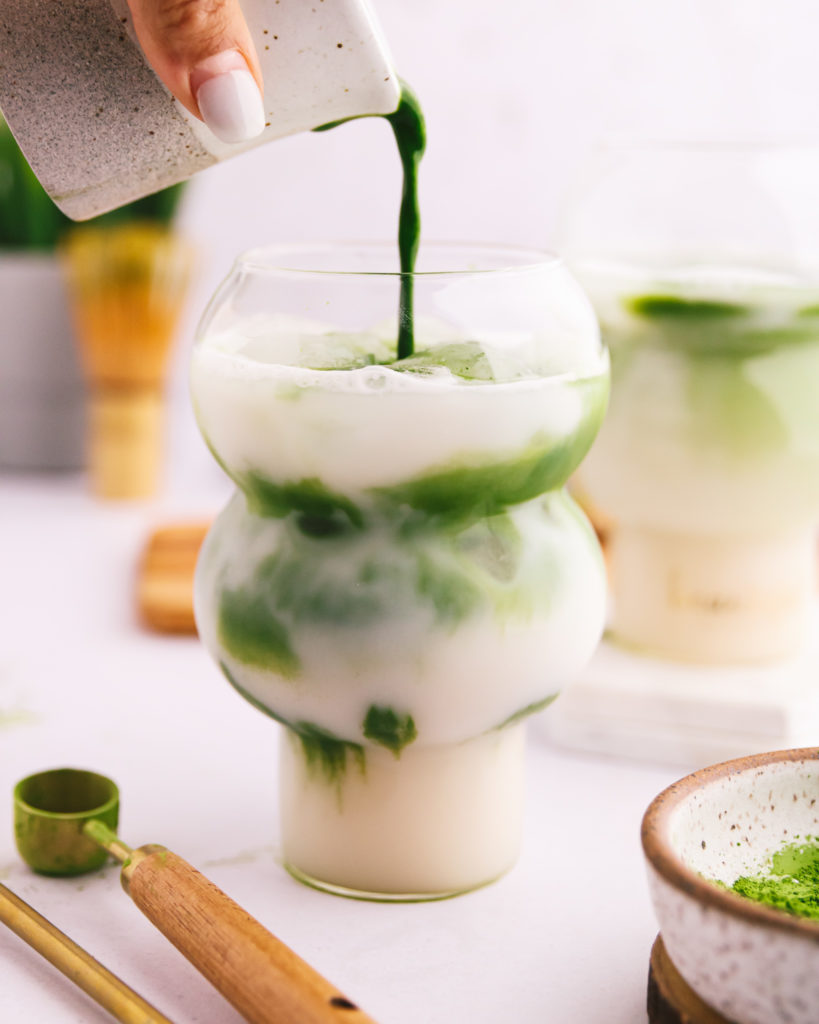 women pouring dairy-free matcha latte into glass