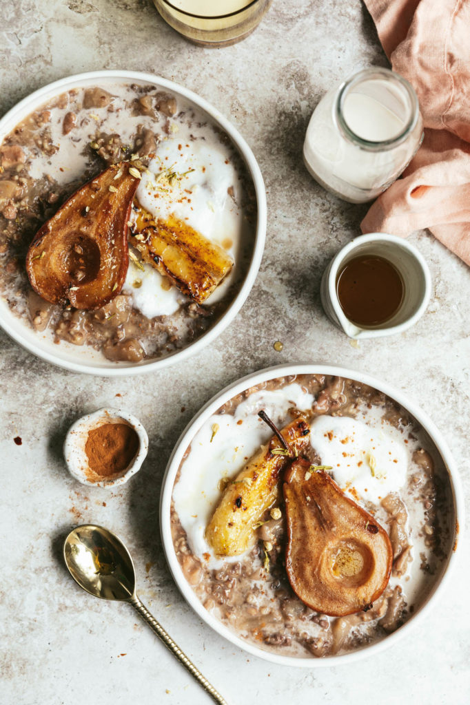Maple Oats & Roasted Pears served on two bowls and paired with milk and maple syrup.
