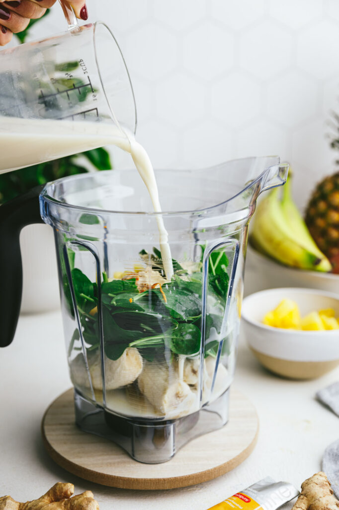 Woman pouring almond milk into a blender