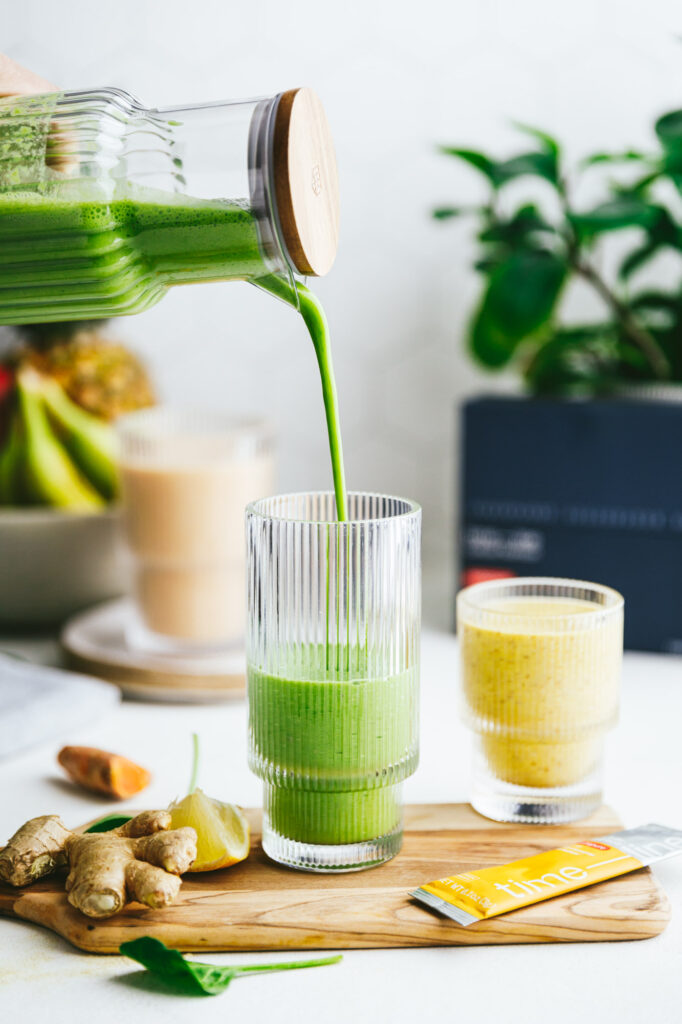 Green smoothie being poured into a glass.
